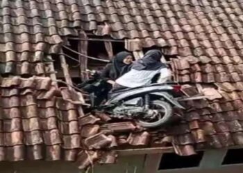 Viral, 2 Gadis Menclok di Atap Rumah Bersama Motornya